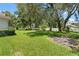 Expansive backyard features lush green grass, mature trees, and a charming white picket fence at 18561 Winding Oaks Blvd, Hudson, FL 34667