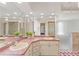 Large bathroom with dual sinks, textured glass shower, mirrors, and neutral color palette at 18561 Winding Oaks Blvd, Hudson, FL 34667