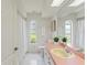 Bright bathroom featuring a pink countertop, white cabinets, and arched window for natural light at 18561 Winding Oaks Blvd, Hudson, FL 34667