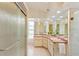 Bright bathroom with dual sinks, decorative mirrors, shower with textured glass door, and light pink color scheme at 18561 Winding Oaks Blvd, Hudson, FL 34667
