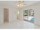 Well-lit bedroom includes tile floor, ceiling fan, closet, and sliding door access to the outdoor pool area at 18561 Winding Oaks Blvd, Hudson, FL 34667