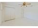 Bedroom with tile flooring, ceiling fan, closet, and private entry door at 18561 Winding Oaks Blvd, Hudson, FL 34667