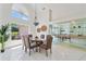 Open dining room with a glass table and decorative chandelier, flowing into the living area at 18561 Winding Oaks Blvd, Hudson, FL 34667