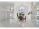 Bright dining room with chandelier, tall windows, tile floors, and decorative built-ins at 18561 Winding Oaks Blvd, Hudson, FL 34667