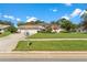 Beautiful home exterior with a well-manicured lawn, lush landscaping, and a spacious three-car garage at 18561 Winding Oaks Blvd, Hudson, FL 34667