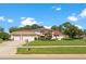Stunning home exterior boasts a three-car garage, immaculate lawn, and mature landscaping at 18561 Winding Oaks Blvd, Hudson, FL 34667