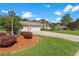 Exterior of a charming single-Gathering home featuring well-maintained landscaping and a lamp post at 18561 Winding Oaks Blvd, Hudson, FL 34667