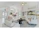 Bright living room with cathedral ceilings, tile floors, modern furnishings, and large windows at 18561 Winding Oaks Blvd, Hudson, FL 34667