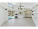 Open living room features high ceilings, large windows, built-in shelving, and pool view through sliding doors at 18561 Winding Oaks Blvd, Hudson, FL 34667