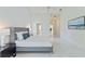 Bright main bedroom with white tile floors, walk-in closet, and en-suite bathroom offers a private and comfortable retreat at 18561 Winding Oaks Blvd, Hudson, FL 34667