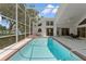 Large screened-in swimming pool with a jacuzzi and outdoor lounge area at 18561 Winding Oaks Blvd, Hudson, FL 34667