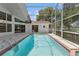Backyard pool boasts refreshing water, an adjacent spa, and an enveloping screened enclosure at 18561 Winding Oaks Blvd, Hudson, FL 34667
