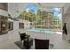 Screened-in pool area featuring a pristine pool, spa, and comfortable seating, perfect for relaxation at 18561 Winding Oaks Blvd, Hudson, FL 34667