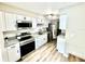 Well-lit kitchen featuring modern appliances, white cabinets, granite countertops, and a sleek stainless steel refrigerator at 1884 Clearbrooke Dr, Clearwater, FL 33760