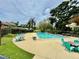 Community pool featuring lounge seating, picnic tables, and mature trees at 1884 Clearbrooke Dr, Clearwater, FL 33760