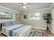 Comfortable bedroom with a ceiling fan, two windows, and a cozy patterned bedspread at 2005 Jefferson Ave, Dunedin, FL 34698