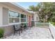 Close up of a welcoming front porch with a seating area, brick accents, and a charming red door at 2005 Jefferson Ave, Dunedin, FL 34698