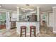 Open concept kitchen featuring white cabinets, stainless steel appliances, and a breakfast bar with stools at 2005 Jefferson Ave, Dunedin, FL 34698