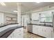 Well-lit kitchen featuring white cabinets, black countertops, stainless steel appliances, and bar seating at 2005 Jefferson Ave, Dunedin, FL 34698