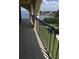 A covered balcony with black metal railings offering expansive views of the waterway and lush greenery at 244 & 243 Mariner Dr # 243-244, Tarpon Springs, FL 34689