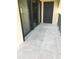 A cozy covered balcony with dark-framed sliding doors and a decorative concrete floor, perfect for relaxation at 244 & 243 Mariner Dr # 243-244, Tarpon Springs, FL 34689