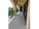 A covered balcony with black metal railings and a decorative concrete floor, providing a private outdoor space at 244 & 243 Mariner Dr # 243-244, Tarpon Springs, FL 34689