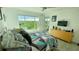 Bedroom with a large window overlooking lush greenery, complemented by a comfortable bed and modern dresser at 244 & 243 Mariner Dr # 243-244, Tarpon Springs, FL 34689
