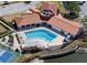 Aerial view of community pool surrounded by lounge chairs and lush landscaping at 244 & 243 Mariner Dr # 243-244, Tarpon Springs, FL 34689