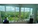 Stunning view of lush greenery and distant rooftops through expansive windows, adding a touch of nature at 244 & 243 Mariner Dr # 243-244, Tarpon Springs, FL 34689