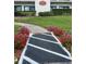 A beautifully landscaped walkway leads to the building entrance, surrounded by vibrant flowers and lush greenery at 244 Mariner Dr, Tarpon Springs, FL 34689