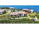 Beautiful aerial view of condominium buildings with terracotta roofs nestled around lush landscaping and a lake at 244 Mariner Dr, Tarpon Springs, FL 34689