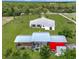 Aerial view featuring a home, lush pastures, and a barn, all enclosed by fencing, creating a private retreat at 28410 Wildlife Ln, Brooksville, FL 34602