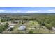 Aerial view of a sprawling property with a home, pastures, and surrounding dense forest, showcasing the landscape at 28410 Wildlife Ln, Brooksville, FL 34602