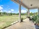 Relaxing back porch with large column, greenery and view of the yard at 28410 Wildlife Ln, Brooksville, FL 34602