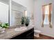 Bright bathroom featuring a large mirror over the vanity and shower with white tiled wall at 28410 Wildlife Ln, Brooksville, FL 34602