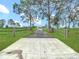Long private driveway leading to a beautiful home, framed by mature trees at 28410 Wildlife Ln, Brooksville, FL 34602