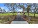 Long paved driveway leading to a well-maintained home with lush landscaping and fenced pastures at 28410 Wildlife Ln, Brooksville, FL 34602
