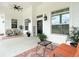 Large covered front porch with ample seating, decorative rugs, and elegant lighting fixtures at 28410 Wildlife Ln, Brooksville, FL 34602
