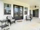 Inviting front porch with wicker chairs and table, perfect for relaxation at 28410 Wildlife Ln, Brooksville, FL 34602