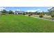 Expansive front yard with lush green grass and a long driveway leading to a beautiful white home at 28410 Wildlife Ln, Brooksville, FL 34602