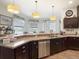 Kitchen featuring a stainless steel dishwasher, granite countertops, and plenty of natural light from surrounding windows at 28410 Wildlife Ln, Brooksville, FL 34602