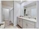 Well-lit bathroom featuring a double sink vanity, shower with curtain, and bright neutral tones at 3329 Fresno Pl, Zephyrhills, FL 33541