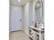 Bright entryway with wood-look floors, white walls, and decorative mirror, welcoming guests inside at 3329 Fresno Pl, Zephyrhills, FL 33541