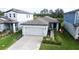 Inviting home featuring a two-car garage, lovely landscaping, and cozy front porch seating at 3329 Fresno Pl, Zephyrhills, FL 33541