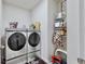 Laundry room with washer, dryer, shelving, cleaning supplies, and laundry accessories at 3329 Fresno Pl, Zephyrhills, FL 33541