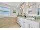 Bathroom with double vanities, granite countertops, and decorative mirrors at 4059 Orient Dr, Hernando Beach, FL 34607