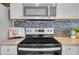 Modern kitchen with stainless steel appliances, granite countertops, and tile backsplash at 4059 Orient Dr, Hernando Beach, FL 34607
