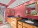 Inviting bathroom features a double vanity with granite countertops and eye-catching red accent walls at 4209 Winding Willow Dr, Tampa, FL 33618
