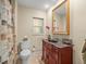 Bathroom featuring a wooden vanity with a marble countertop, a toilet, and shower with a patterned curtain at 4209 Winding Willow Dr, Tampa, FL 33618