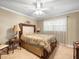 Cozy bedroom featuring a ceiling fan, carpet, and a queen bed with decorative lamps at 4209 Winding Willow Dr, Tampa, FL 33618